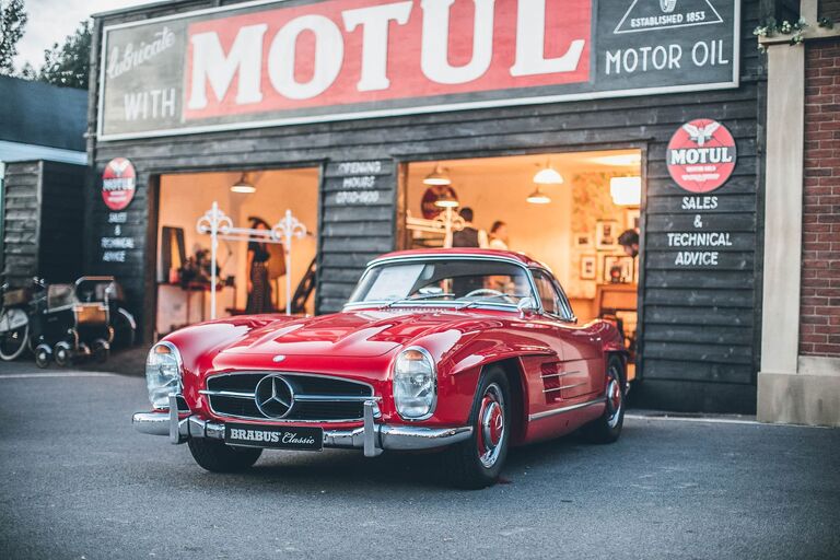 Oldtimer vor Werkstatt mit Motul-Schild, Symbol für Automotive