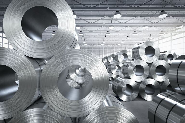 Große Metallrollen in einer Halle, Symbol für die Metallindustrie