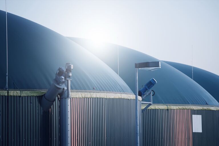 Biogasanlage mit Fermentern im Gegenlicht, Symbol für Energiegewinnung